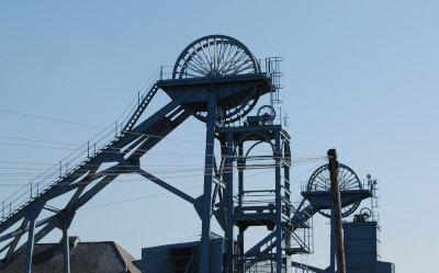 Winding gear at a disused mine juts up into the sky.