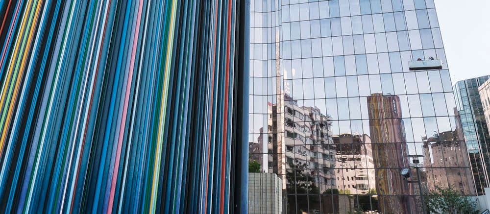 A multicoloured, striated chimney juts into the sky of La Defénse
