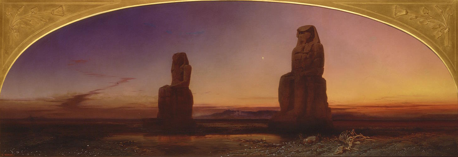 Two grand pharaohnic statues in the desert by dusk