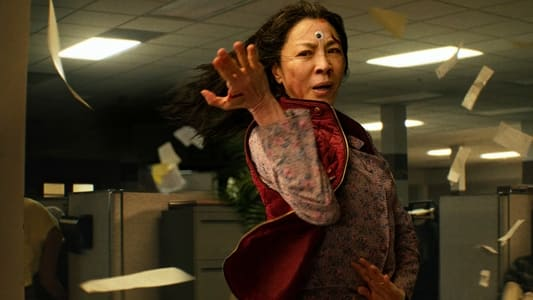 Michelle Yeoh with a googly eye on her face in an office