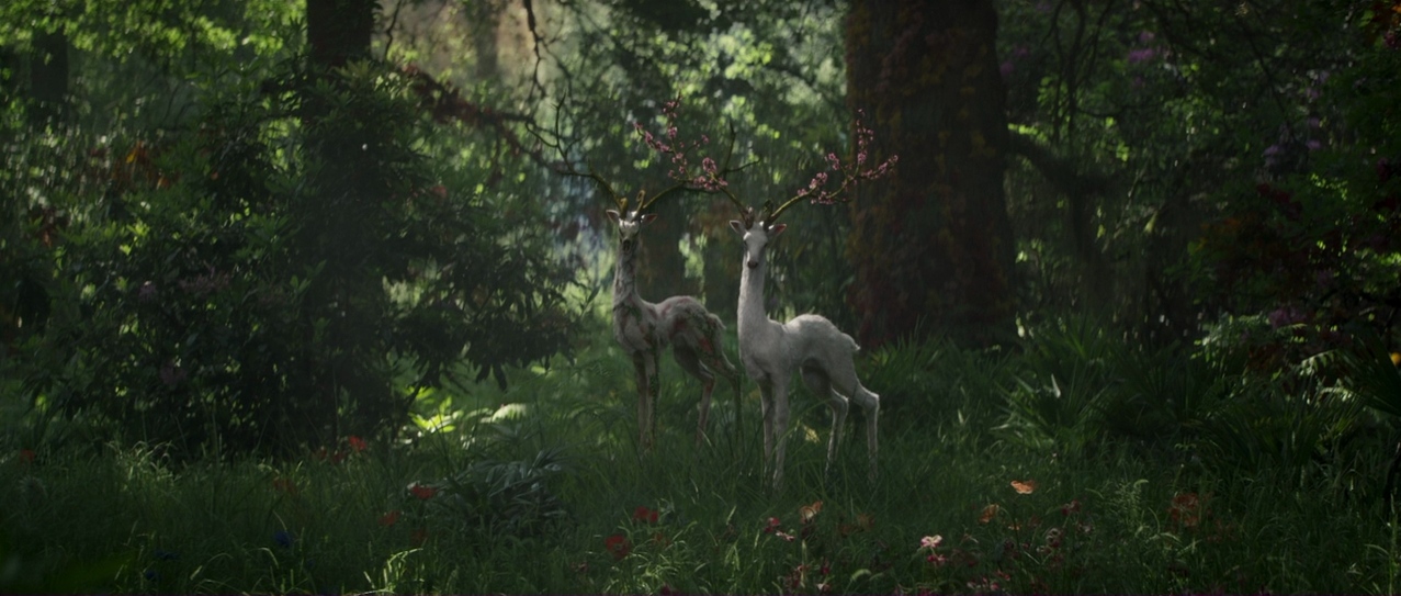 Two mutated deer, their antlers clad in vibrant flowers, stand in a beautiful verdant forest, looking quizzically at the camera