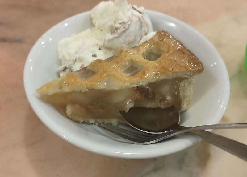 A slice of apple pie and ice cream in a bowl
