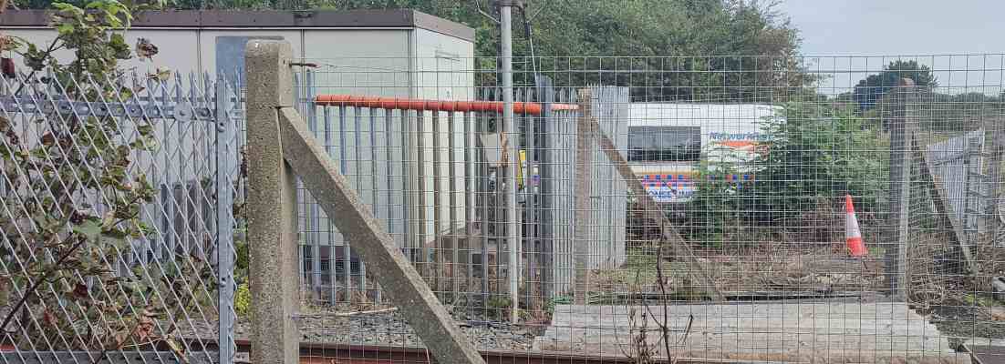 Behind wire fences and train tracks, a van belonging to Network Rail is visible.