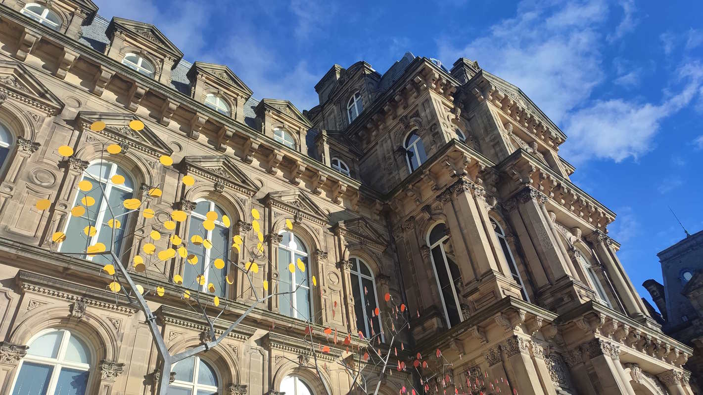 A shot looking up at an old Georgian palace with glass trees in the foreground