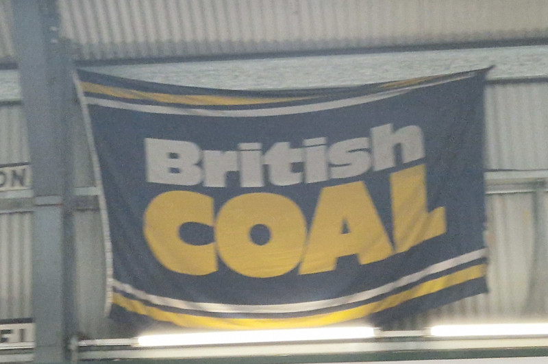 A blue, white and yellow flag with “British COAL” in big bold letters