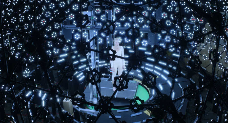A live-action Robin Wright stands in the centre of a sphere of cameras blaring at her