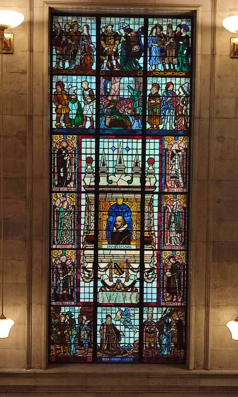 A stained glass window depicting the works of Shakespeare