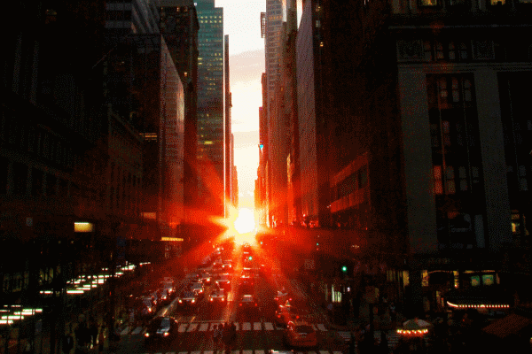 The sun shining directly down a city street.