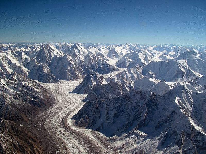 A glacier flowing through mountains.
