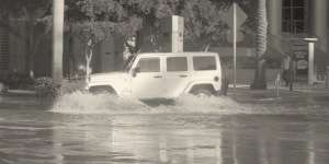 A car driving through a flooded street.