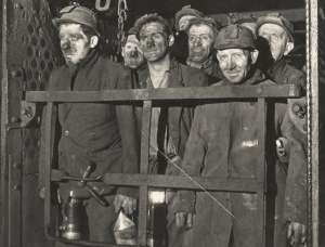 Coal miners standing in a lift shaft.